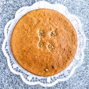 A round low FODMAP cake decorated with walnuts