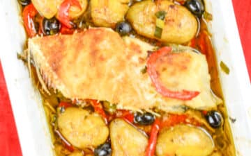 travessa com posta de bacalhau rodeada de batata a murro, azeitonas e pimento vermelho